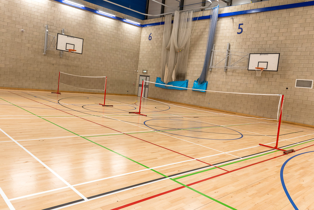 Indoor sports hall with wooden floor and basketball hoops