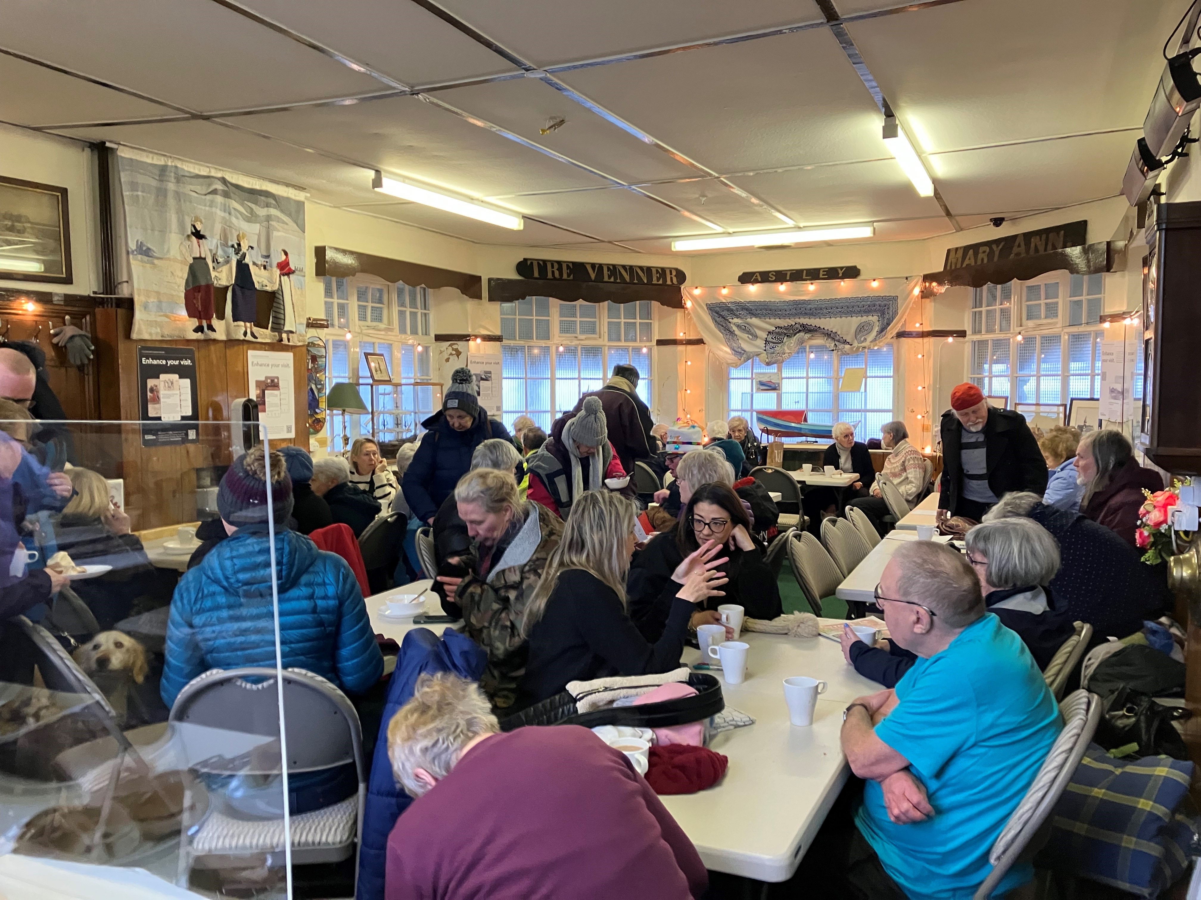 Community gathered in centre drinking hot drinks and talking