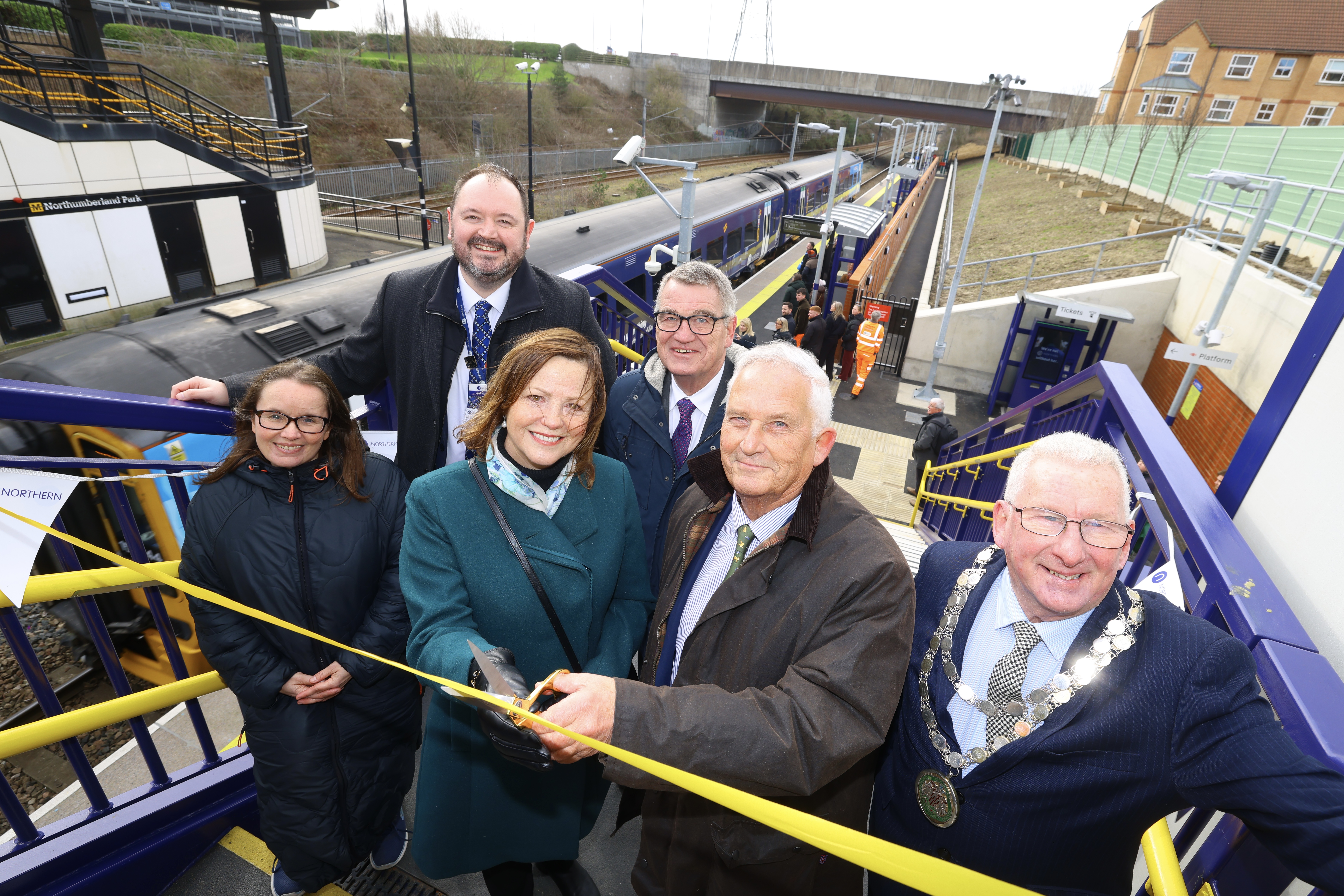 A group of people standing at Northumberland Park metro station at the official opening. 