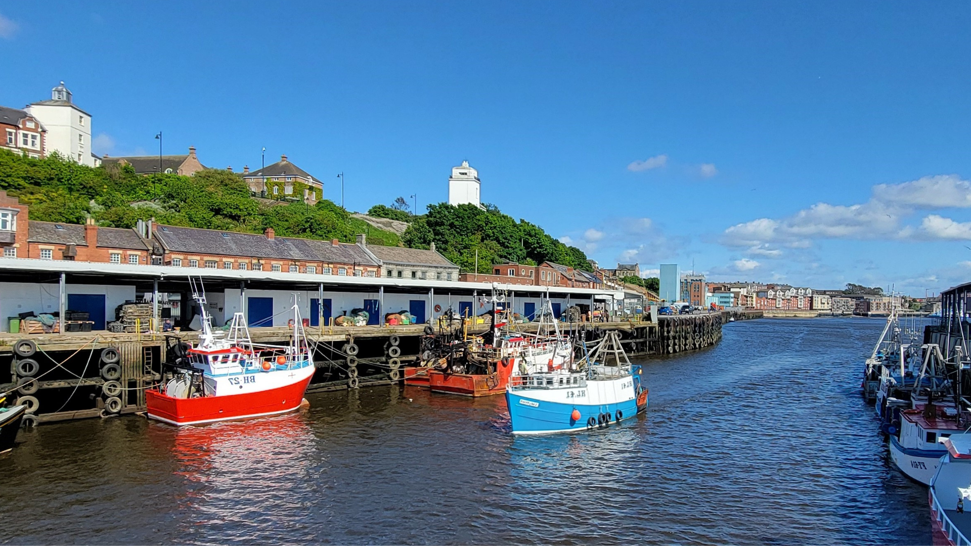 Boats on a river with a dock behind