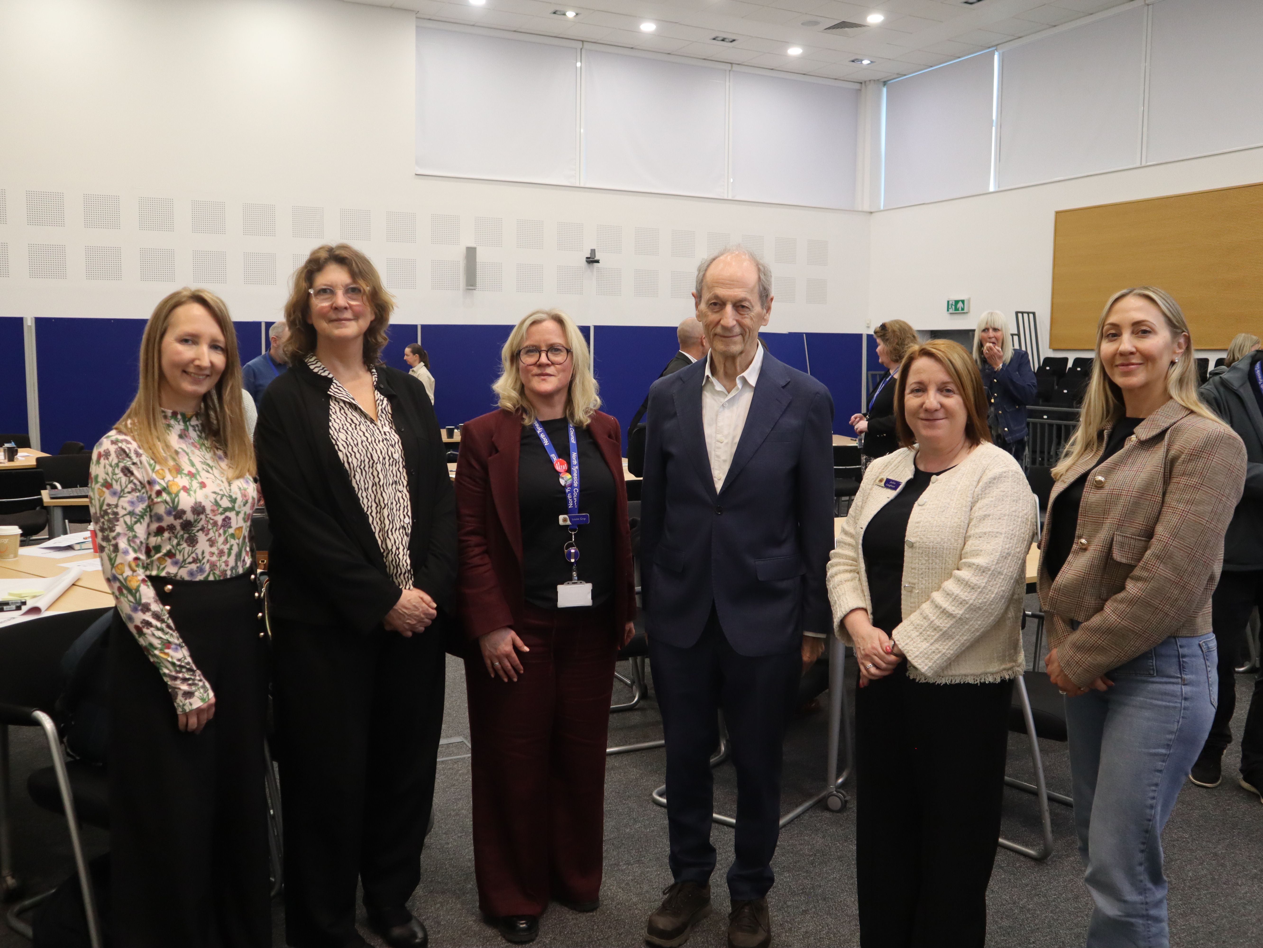 An image of Sir Michael Marmot with his team and senior officers from North Tyneside Council in the committee chamber with tables and chairs