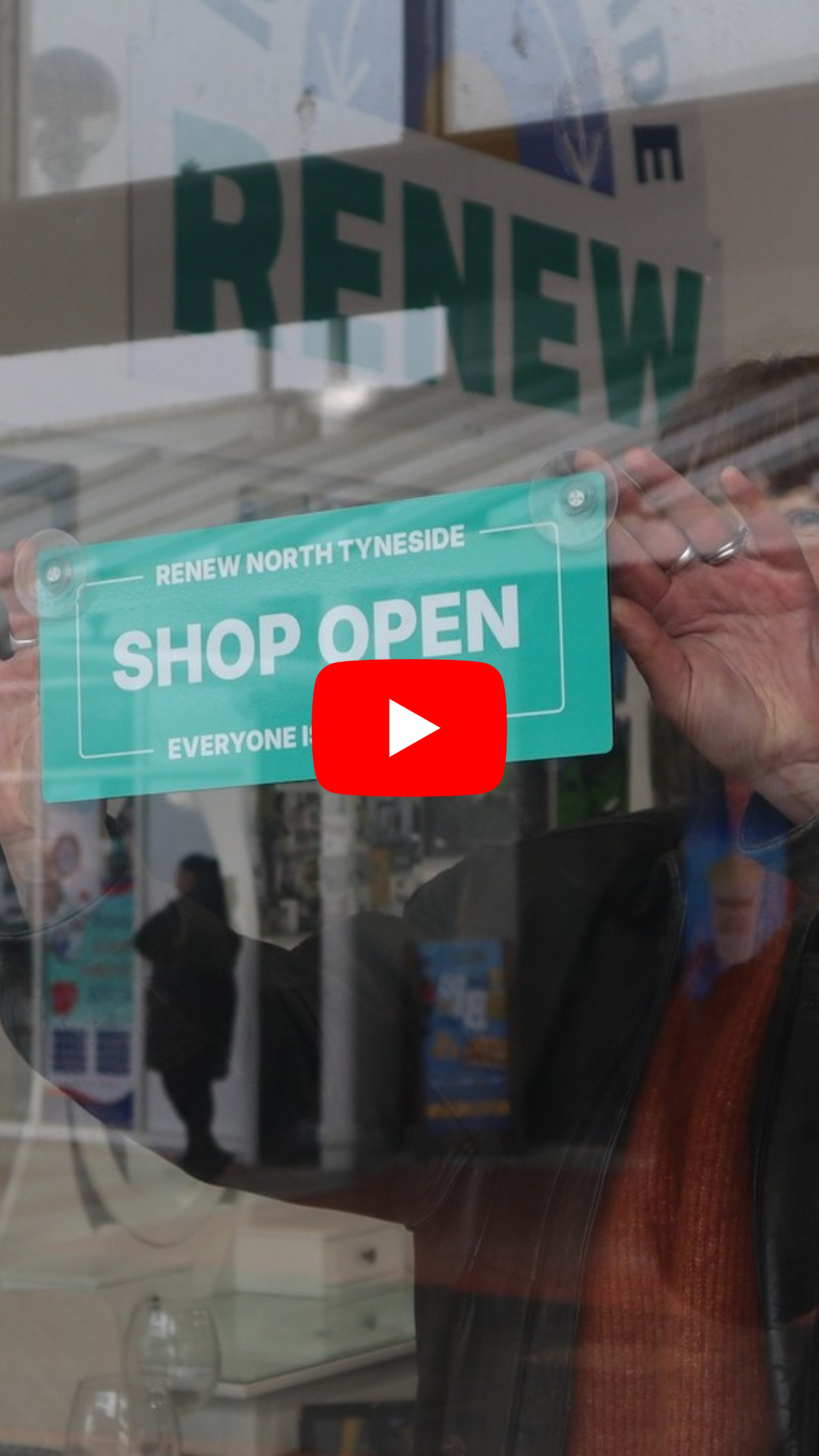 Reuse shop open sign in shop window with YouTube video player button in centre