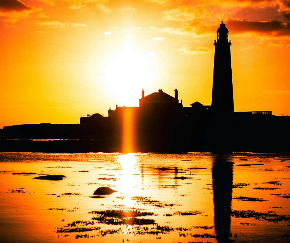 St Mary's lighthouse and island lit up by a glowing Summer solstice sun