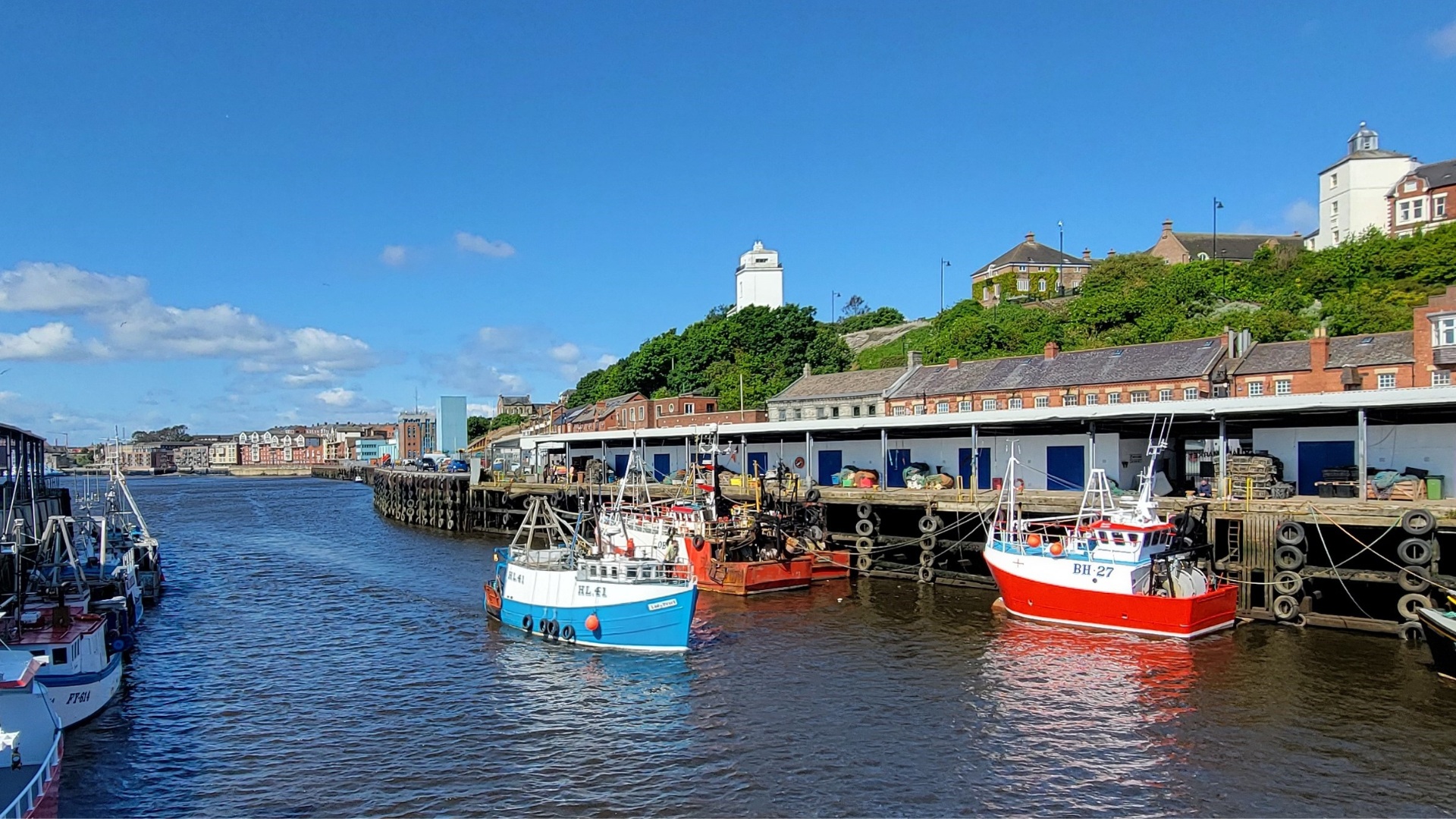 Boats on a river with a dock behind