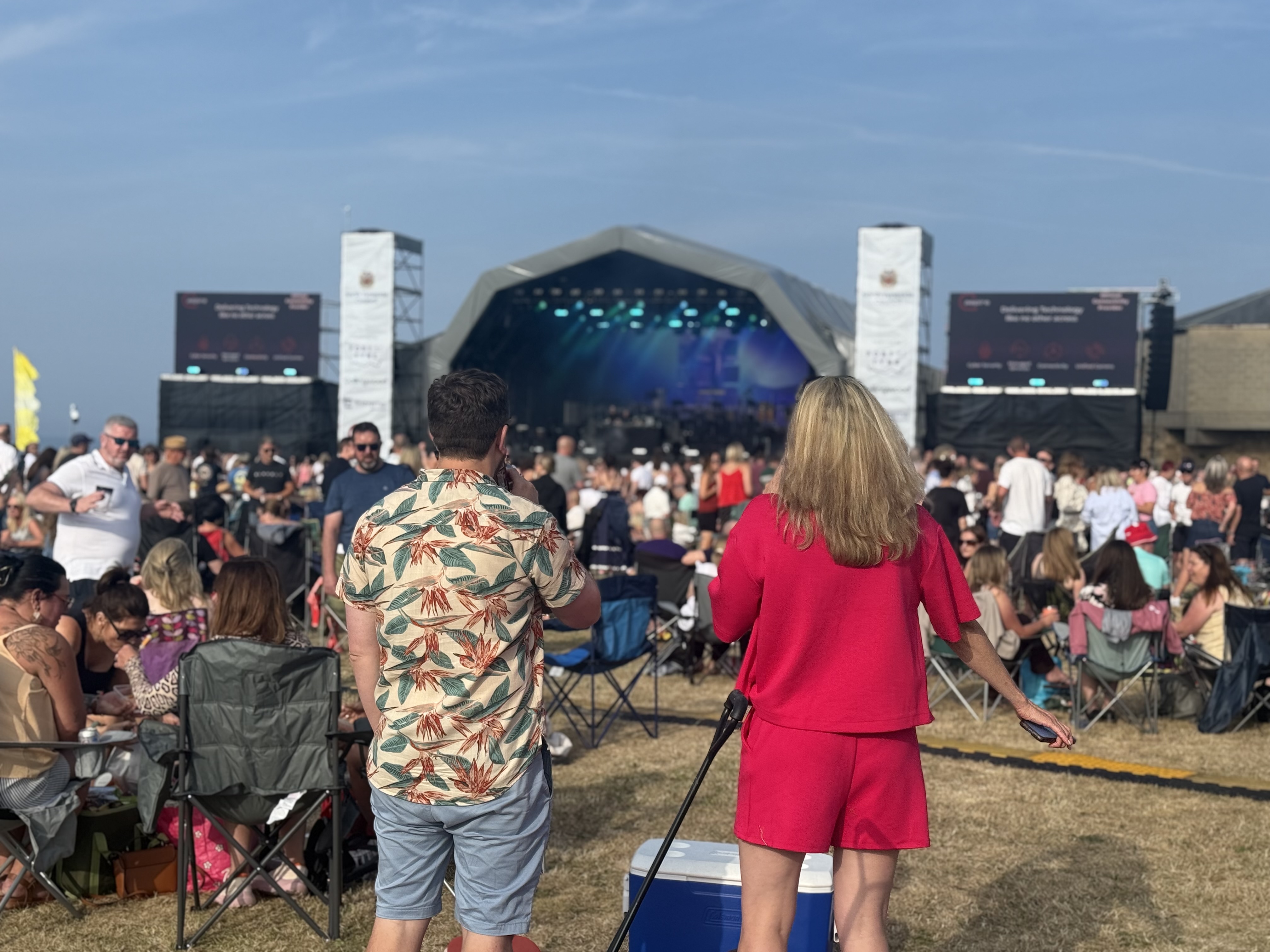 A man and a woman gazing, from a distance, upon the great stage.