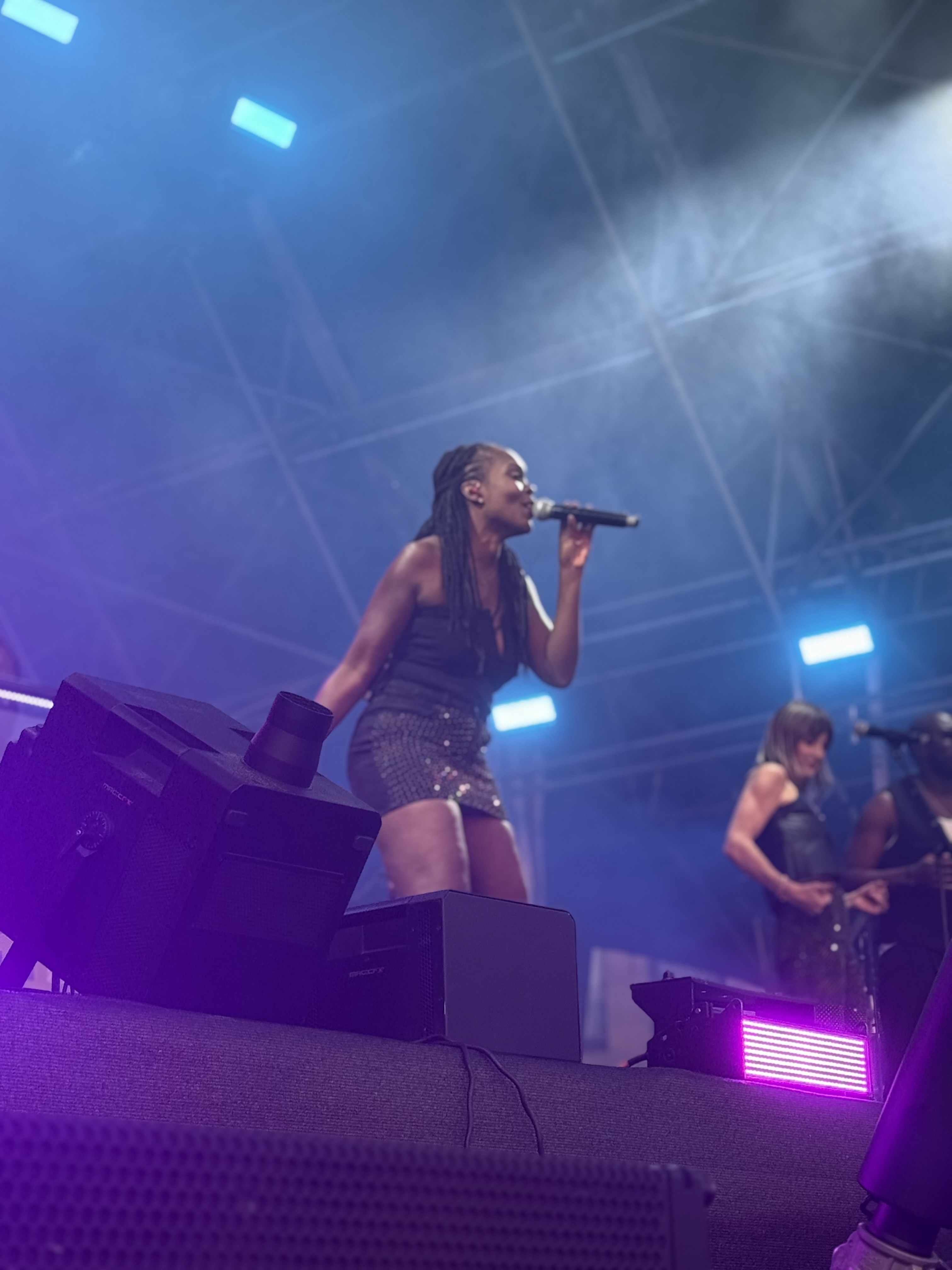 A performer singing under the blue stage lights
