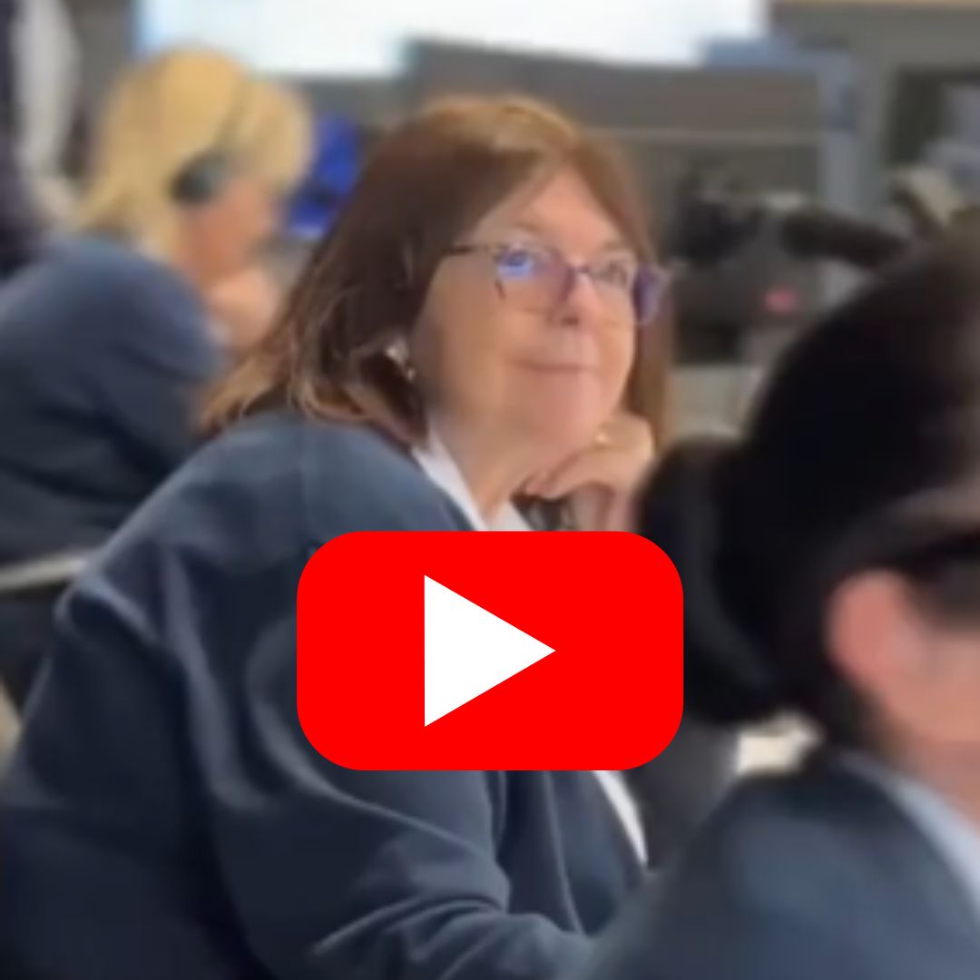 Team member pictured in the Care Call contact centre with red youtube play button at centre