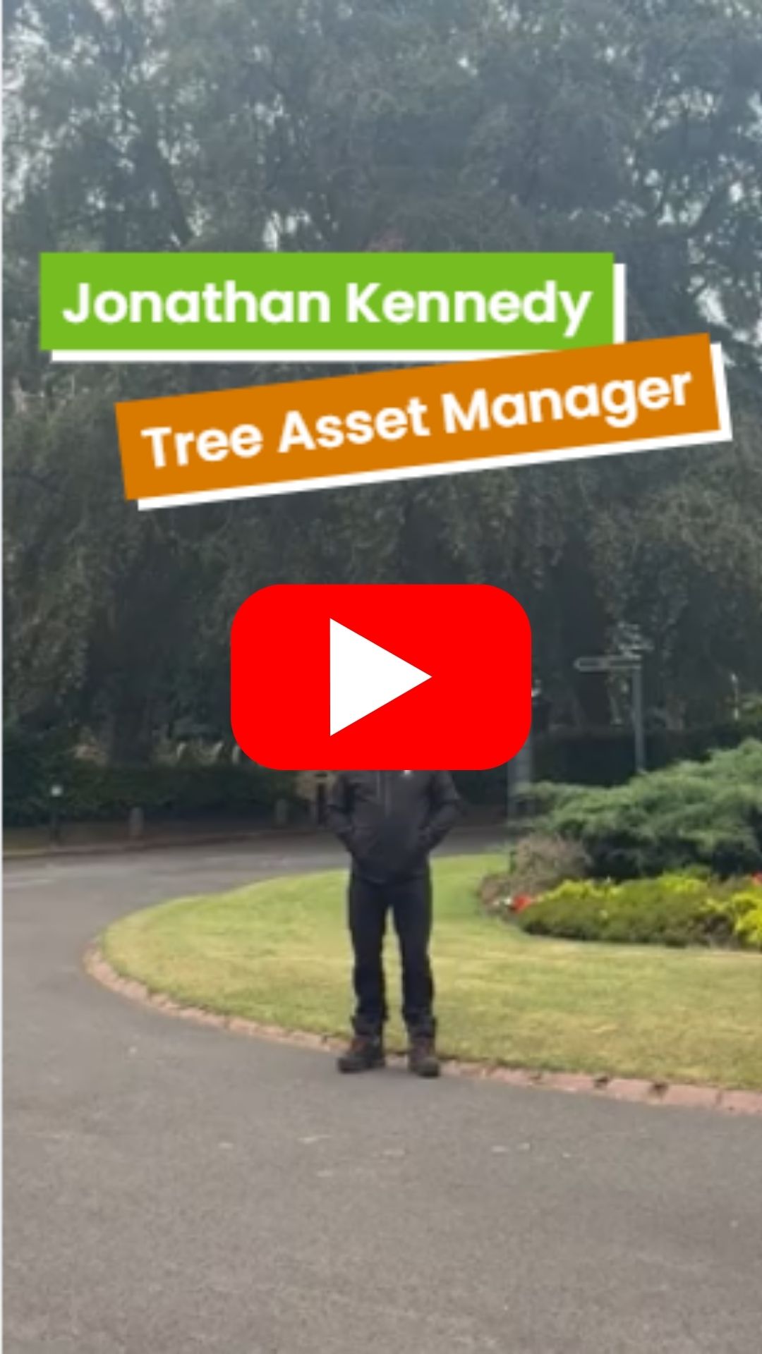 A man standing in front of a beech tree in a cemetery 