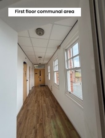Long corridor with wooden floor and windows