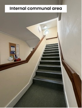 Stairs with a grey carpet and wooden handrail