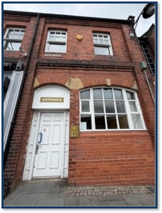 Front of red brick building with white door