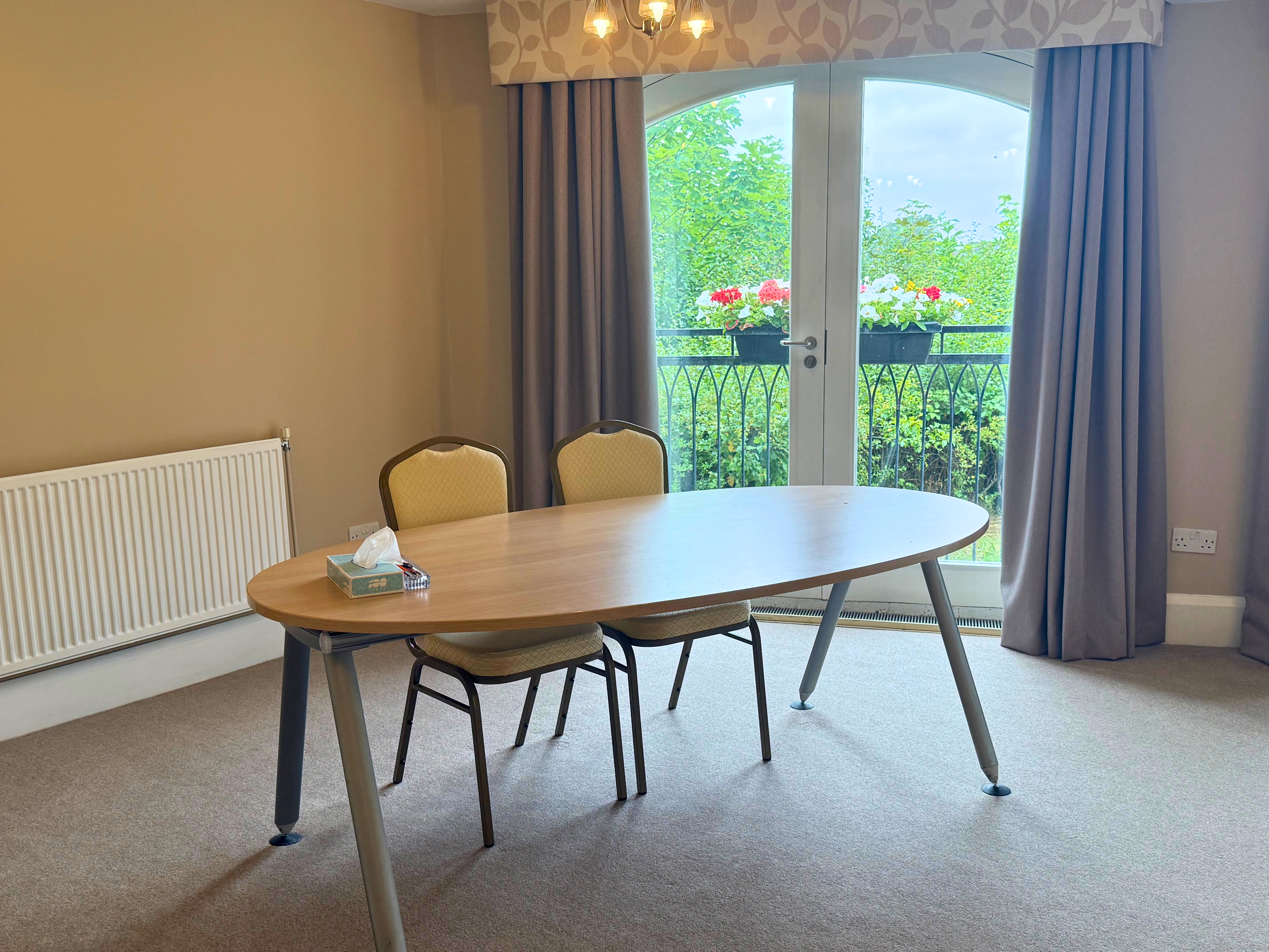 Two chairs at a round table in the corner of a cream coloured room