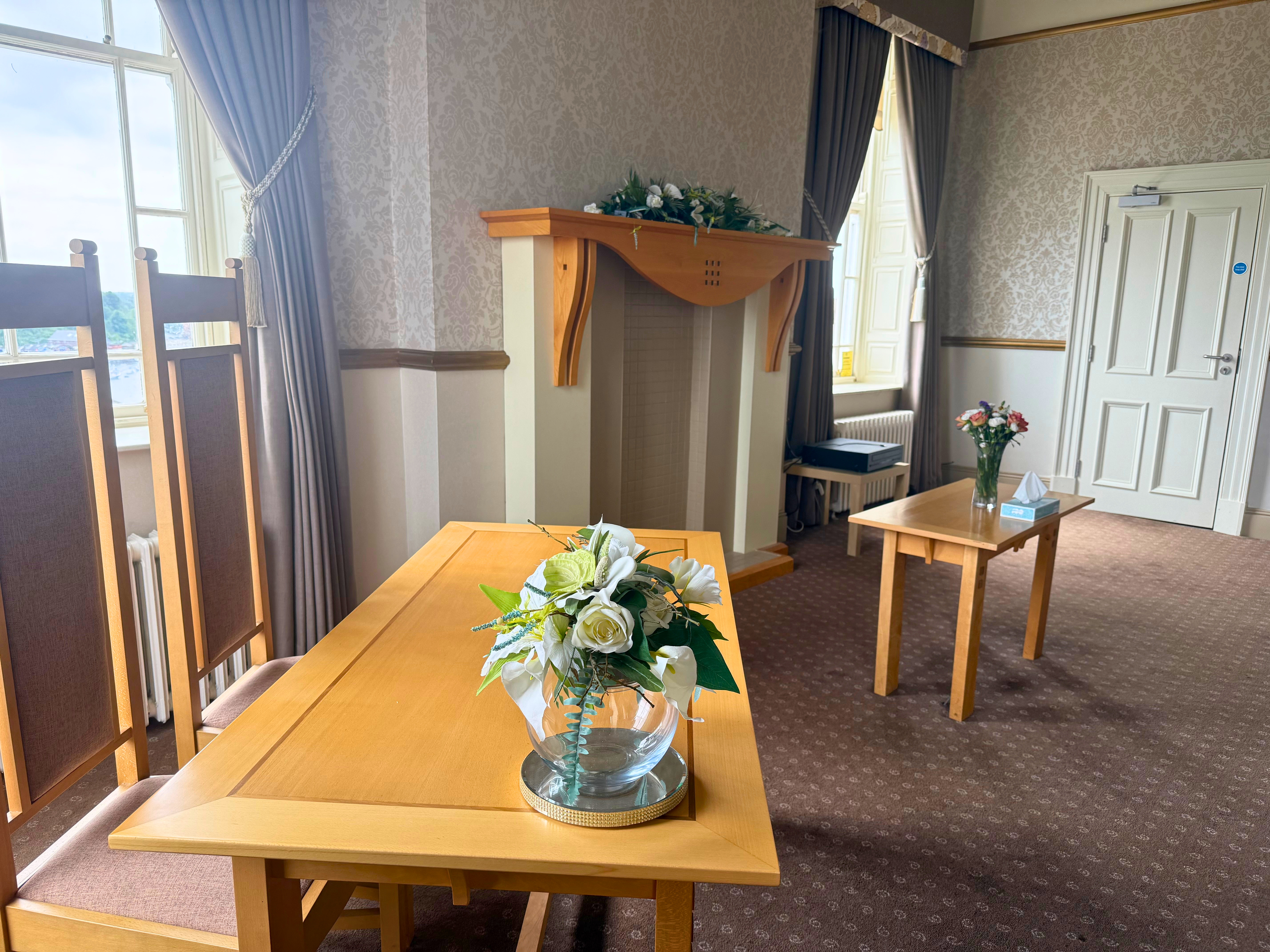 Two tables with vases of flowers and chairs