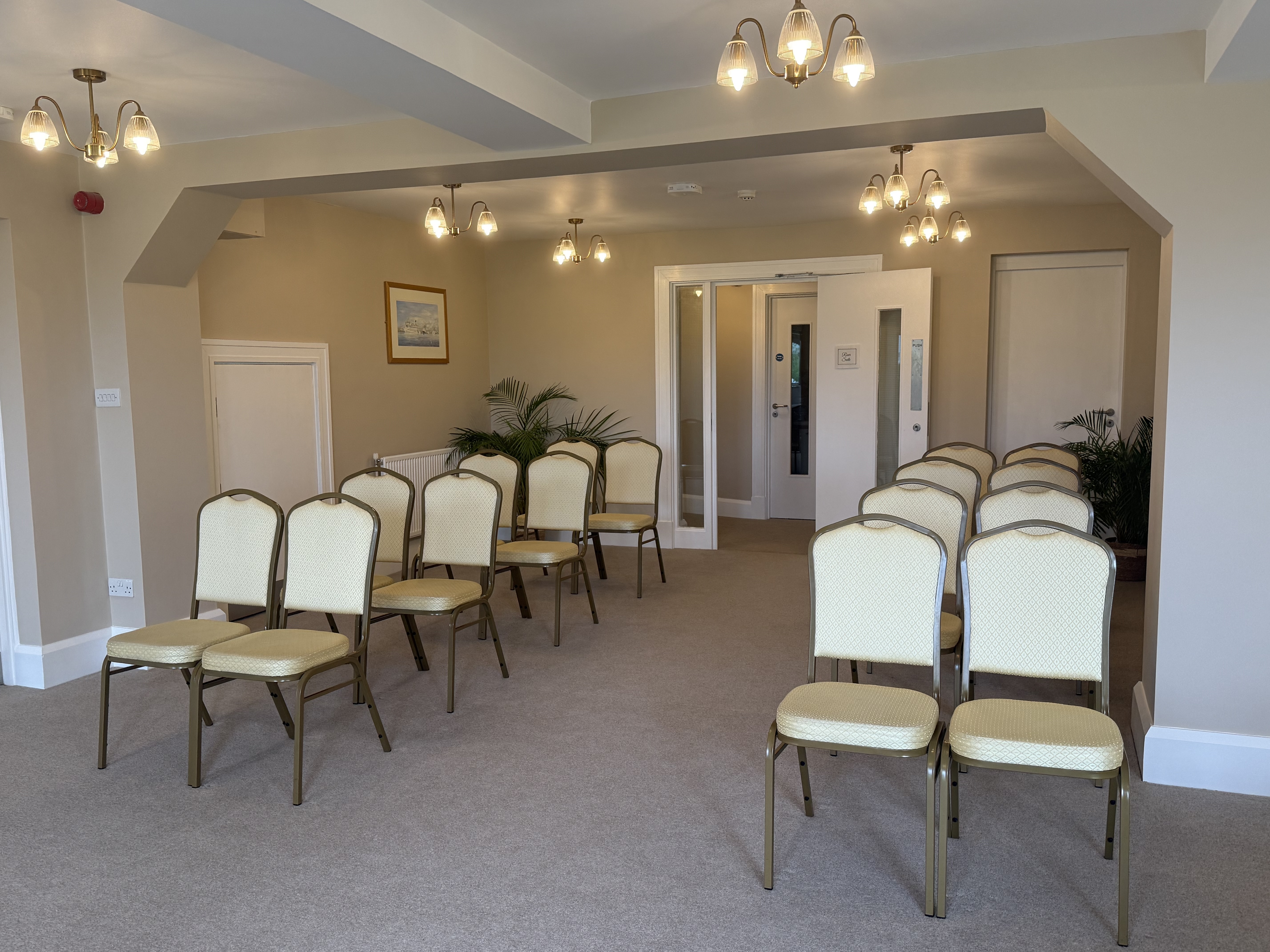 A bright room with rows of chairs lined up for a wedding