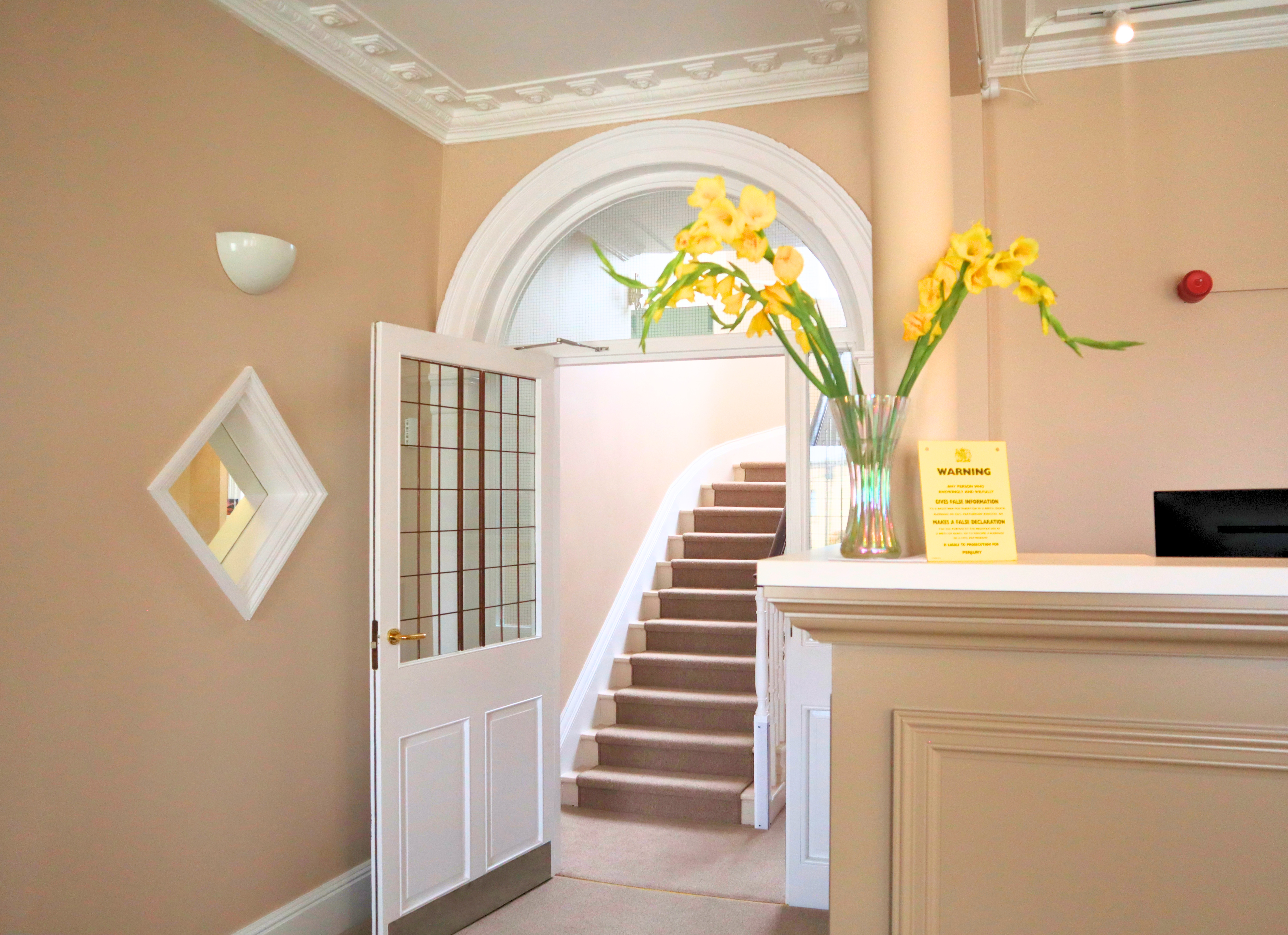 A reception room with a light coloured desk