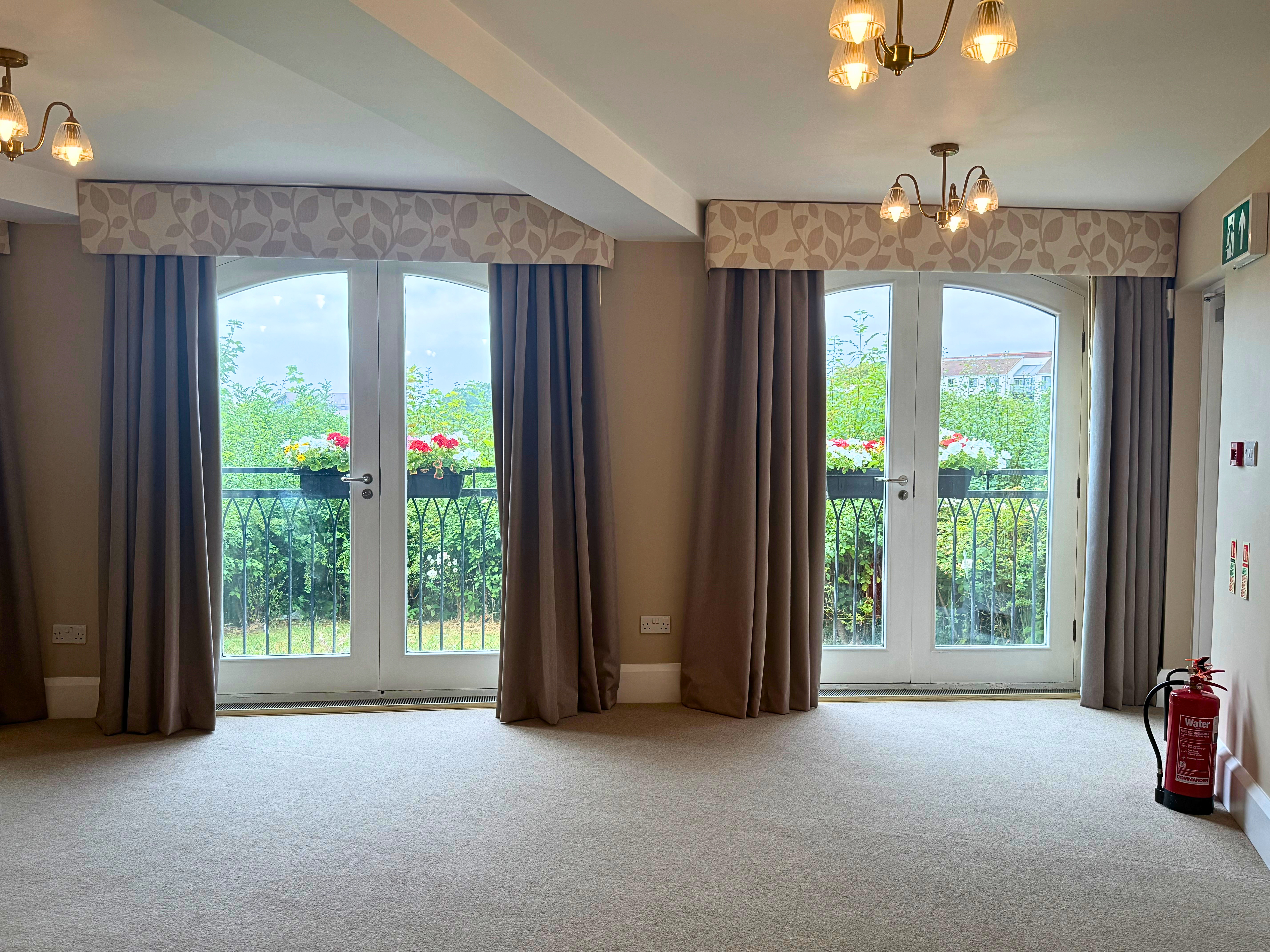 Two large windows with neutral coloured curtains