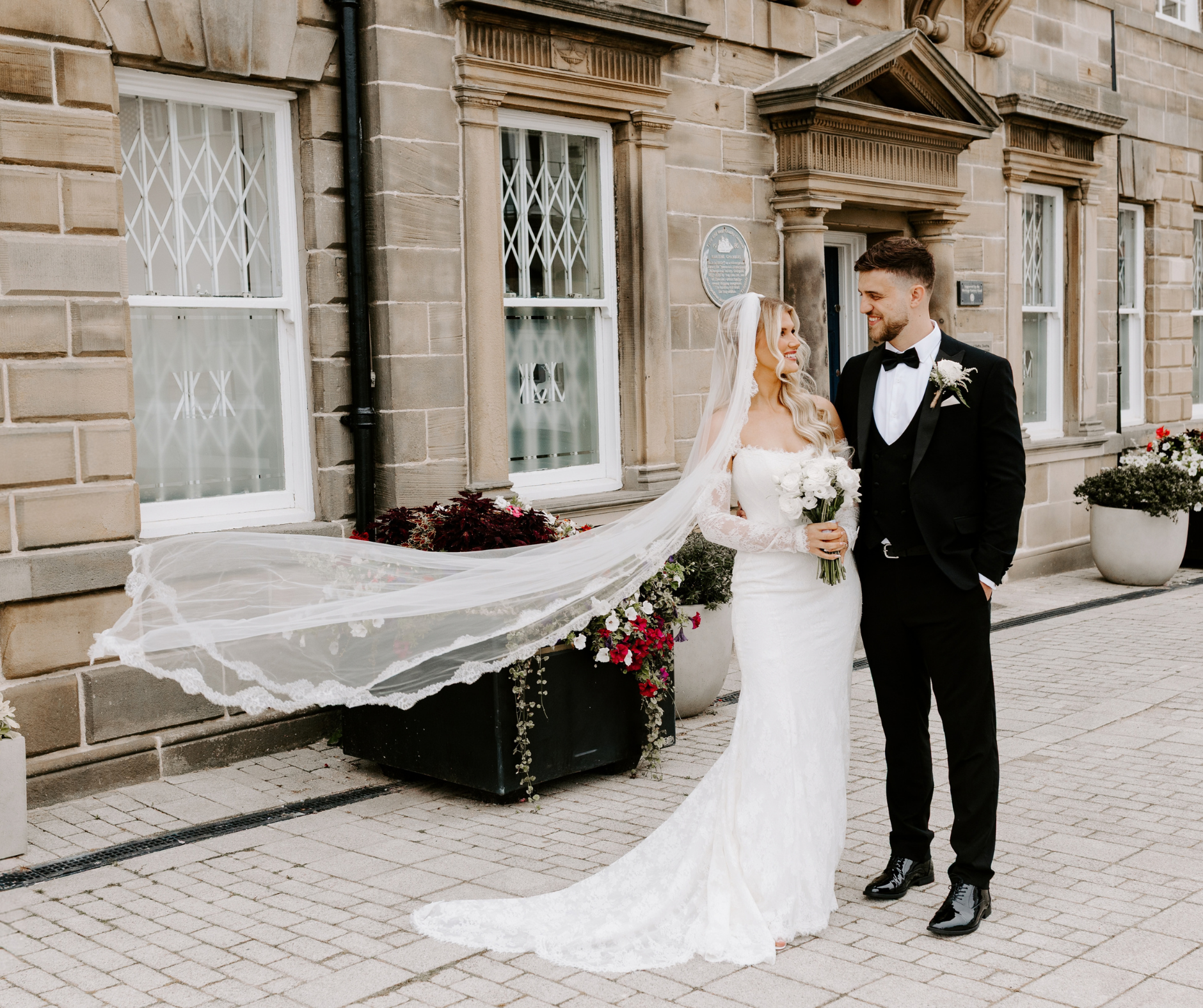 A bride and groom stand in front of the Maritime chambers
