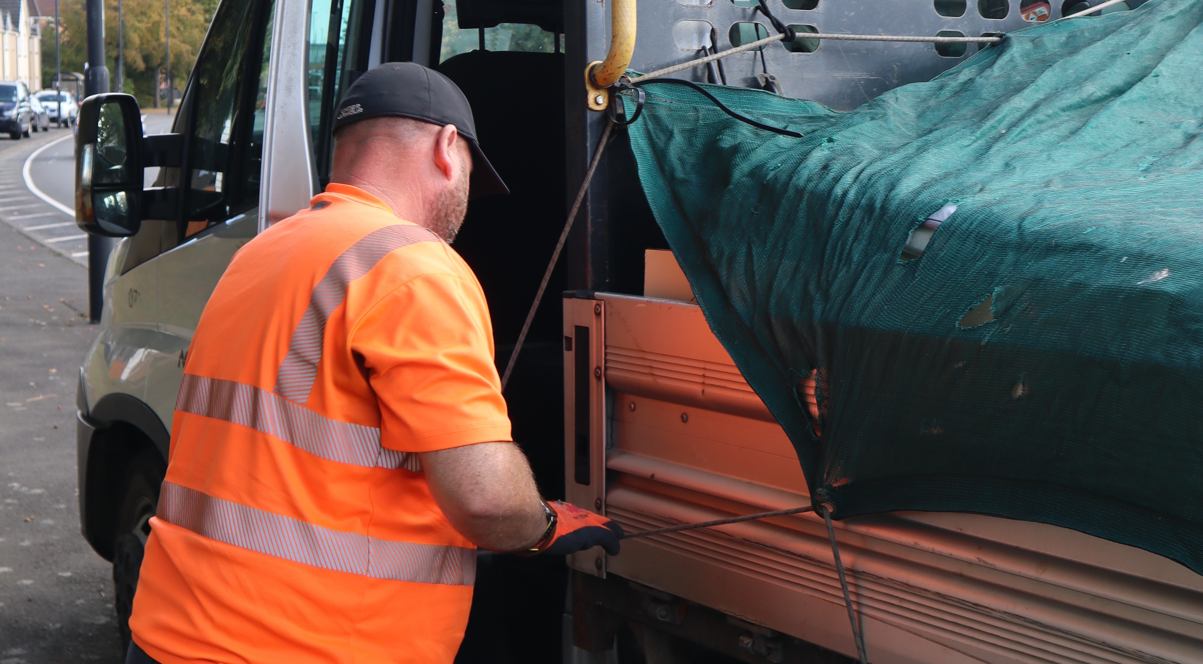 Council operative putting fly-tipped materials into the van 