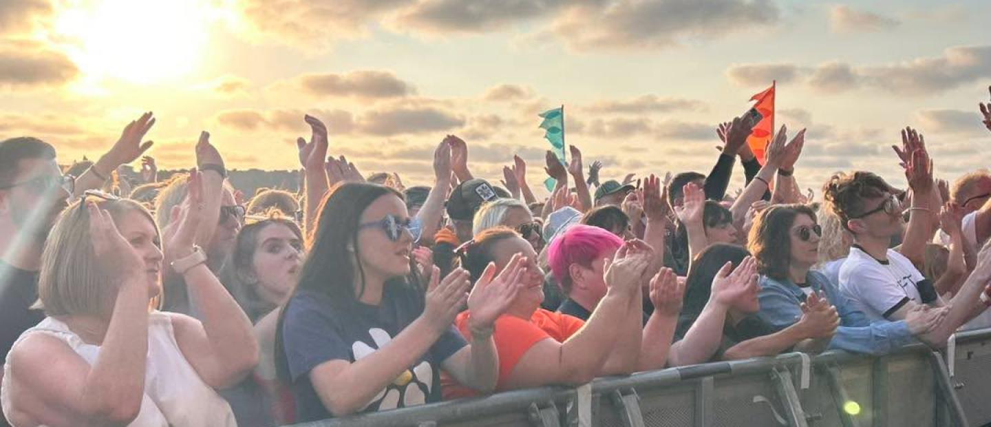 Cheering crowds enjoying the show in front of the sunset.