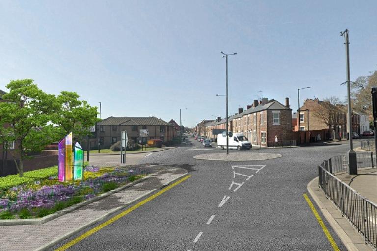 An artist's impression of the future plans for planting and an art installation to the left hand side of the road with the five arm roundabout in the background and a van in the distance and a blue sky