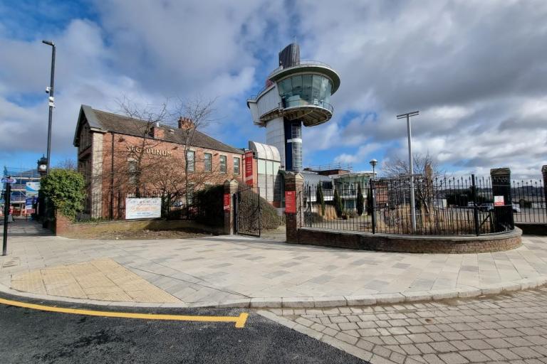 A colour photo showing the active travel route with a widened footpath in front of the gates of Segedunum Roman Fort