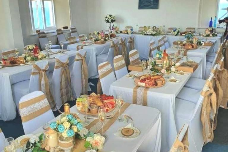 room decorated with tables set for wedding breakfast