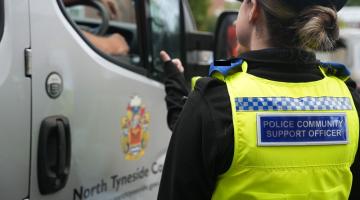 Back of Police Community Support Officer standing next to North Tyneside Council van