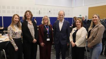 An image of Sir Michael Marmot with his team and senior officers from North Tyneside Council in the committee chamber with tables and chairs