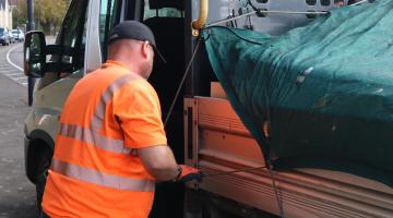 Council operative putting fly-tipped materials into the van 