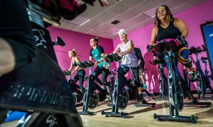 People cycling on exercise bikes