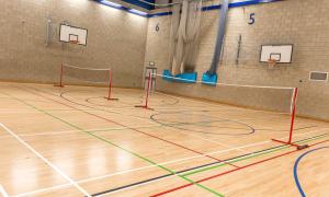 Indoor sports hall with wooden floor and basketball hoops
