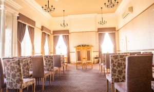 chairs down the side of an aisle with a table at the end