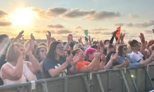Cheering crowds enjoying the show in front of the sunset.