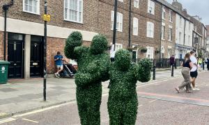 Two waving bushes stand below the bunting, stringed streets.