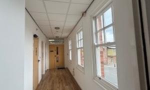 Long corridor with wooden floor and windows