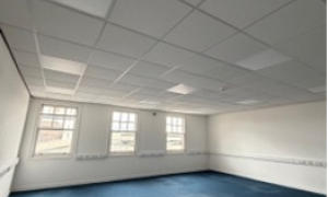 Empty room with three windows and carpet