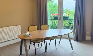 Two chairs at a round table in the corner of a cream coloured room