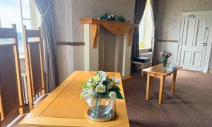 Two tables with vases of flowers and chairs