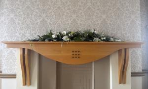 A mantlepiece with a display of white flowers decorating it
