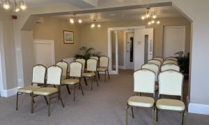 A bright room with rows of chairs lined up for a wedding