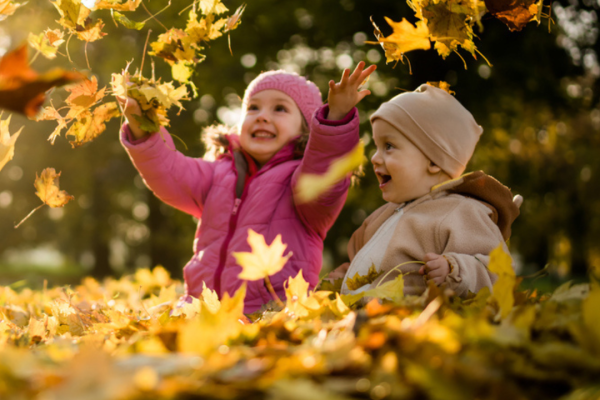Image of children playing in autumn leaves