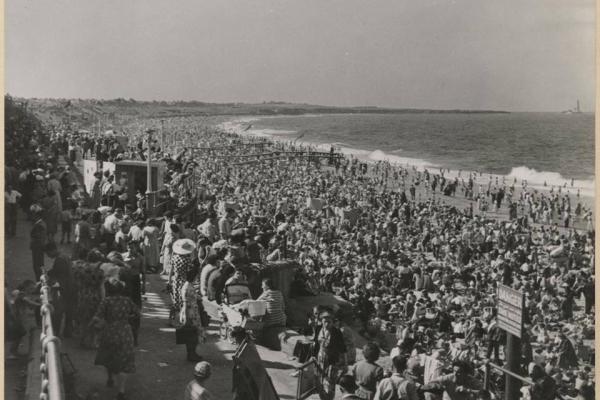 A crowd of people next to the sea