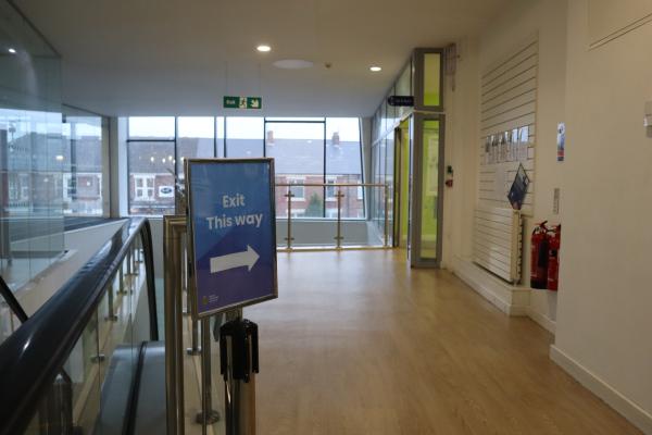 sign inside a library with an arrow showing the way out