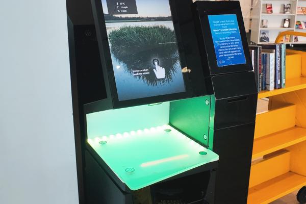 a self service machine with a screen and scanner