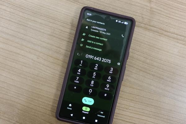 a mobile phone with screen open and the number 01916432075 typed into it