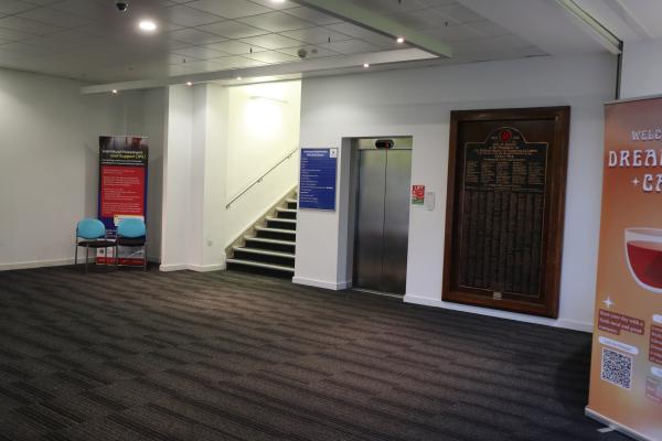Open space in a building with a staircase and silver doors of a lift