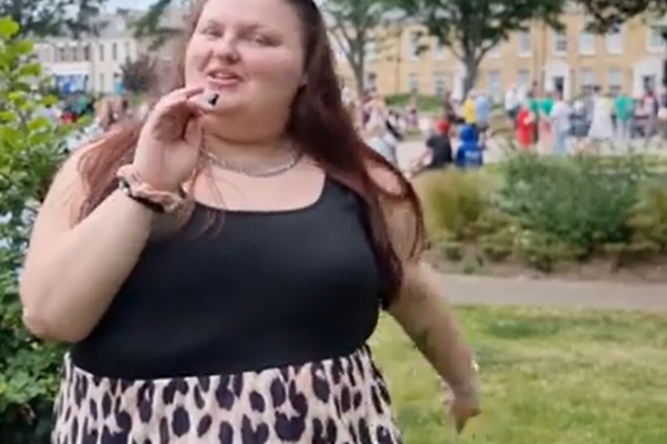 Big community conversation. Woman with a microphone with a park behind her